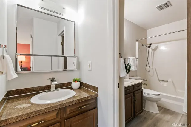 a bathroom with a granite countertop sink toilet and shower