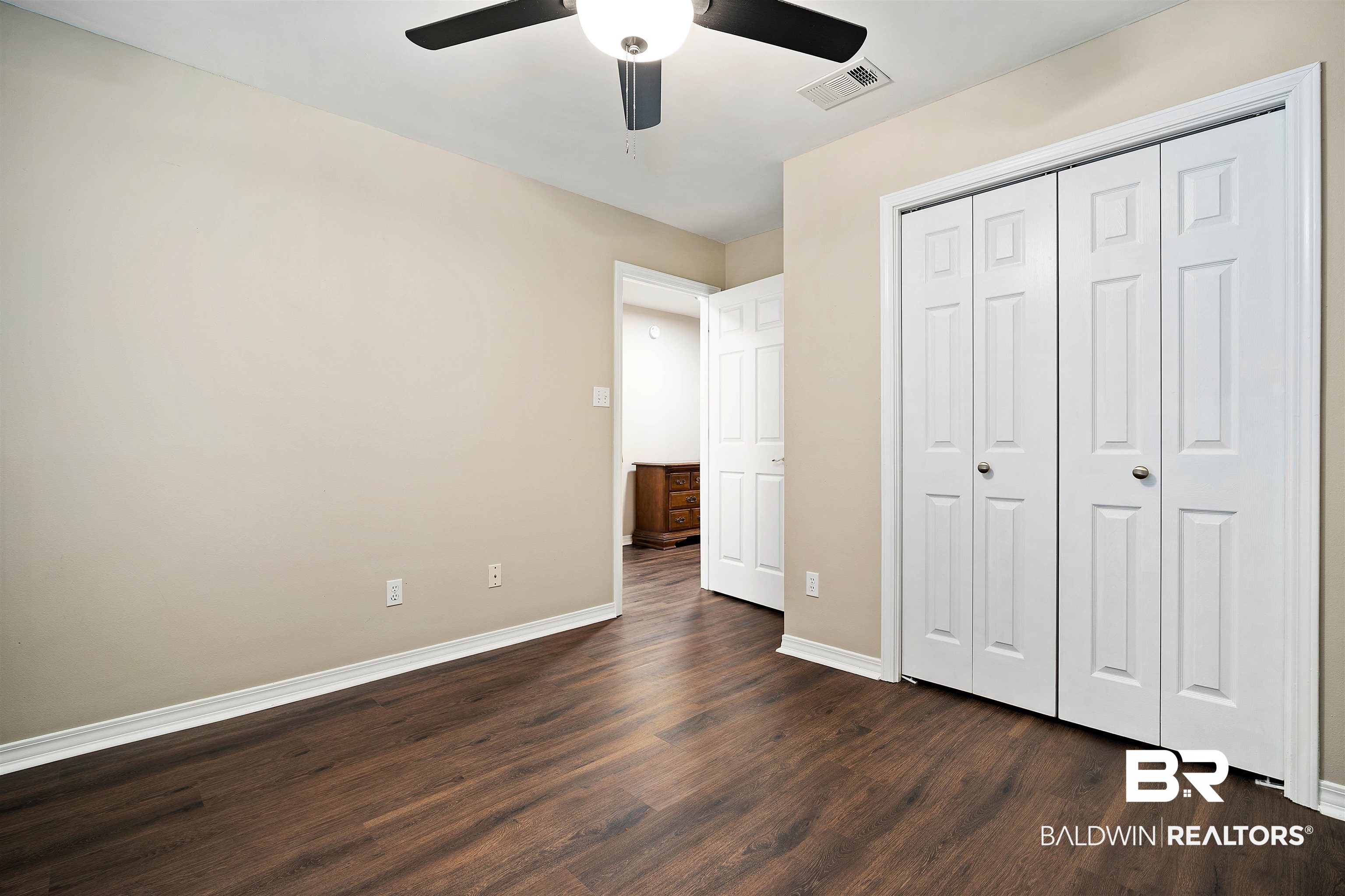628 Spring Lake Court Mobile, AL 36695 - Photo 16 of 25 Unfurnished bedroom featuring ceiling fan, dark hardwood / wood-style flooring, and a closet