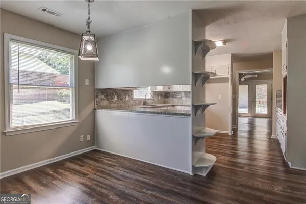 a view of a room with wooden floor and a window