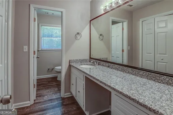 a bathroom with a granite countertop sink and a mirror