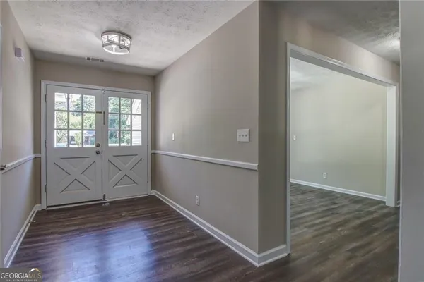 an empty room with wooden floor and windows