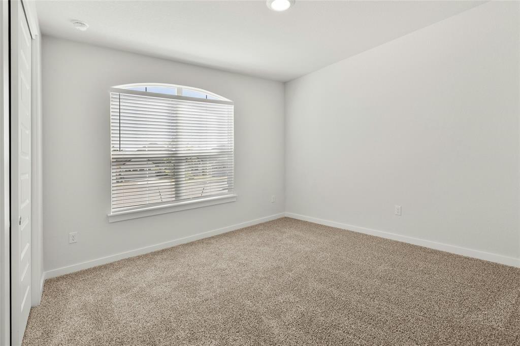 113 Shadow Oak Cove Georgetown, TX 78628 - Photo 17 of 40 Well-lit and tranquil, this bedroom provides a peaceful retreat with plush carpeting and a gracefully arched window.