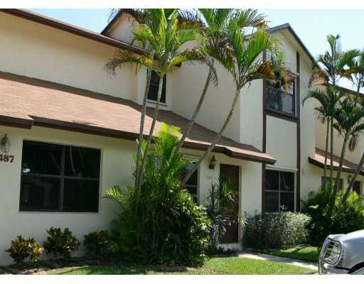 a view of a house with a potted plant and floor to ceiling window and potted plants