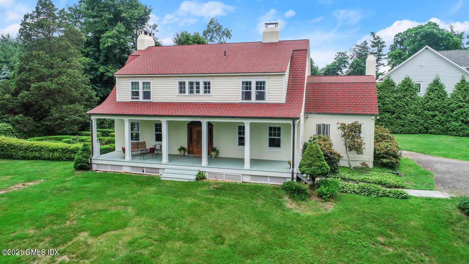 28 Sachem Road Greenwich, CT 06830 - Photo 3 of 36 a front view of a house with a yard table and chairs