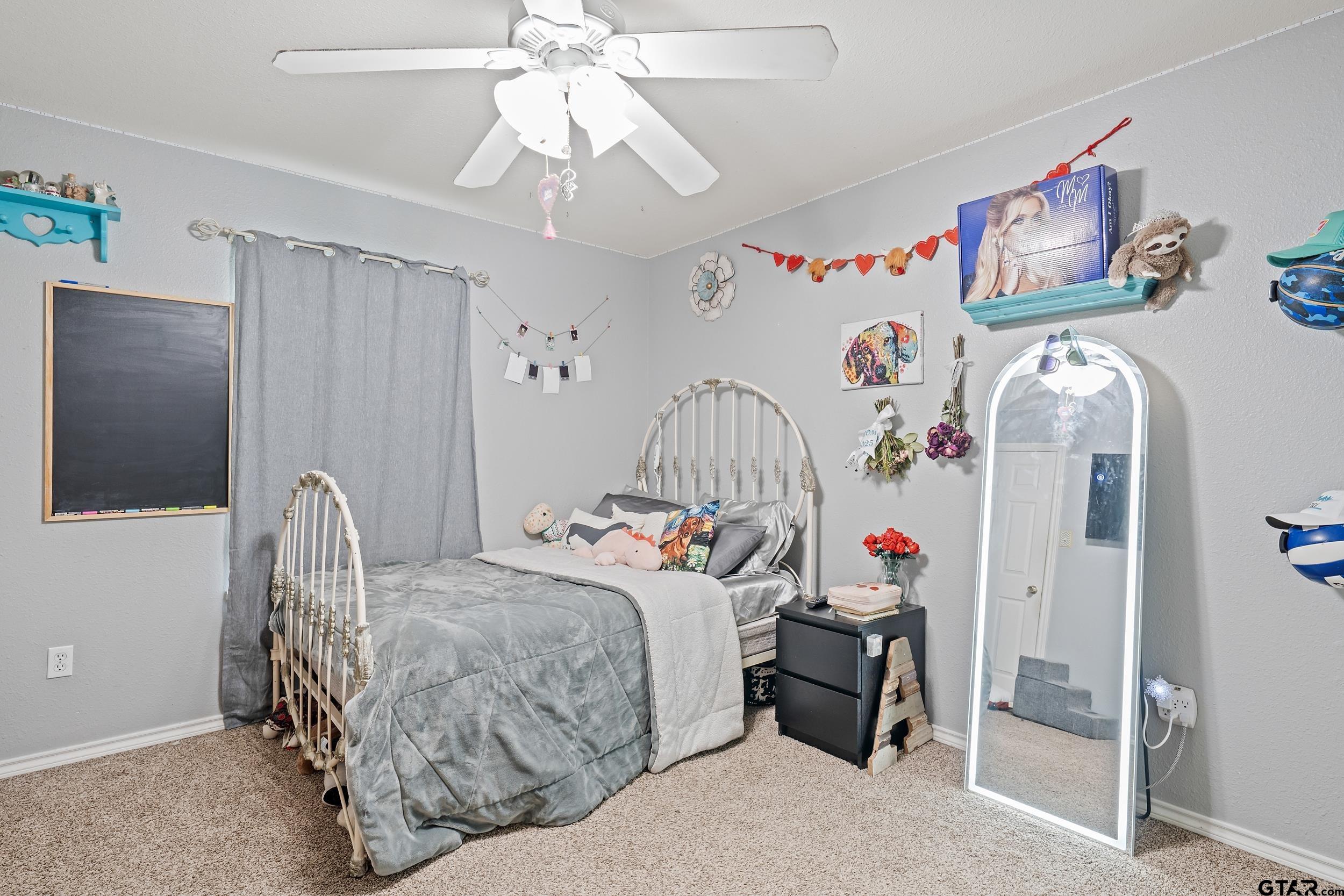 200 David Hawkins, TX 75765 - Photo 19 of 36 a bedroom with a bed and a chandelier