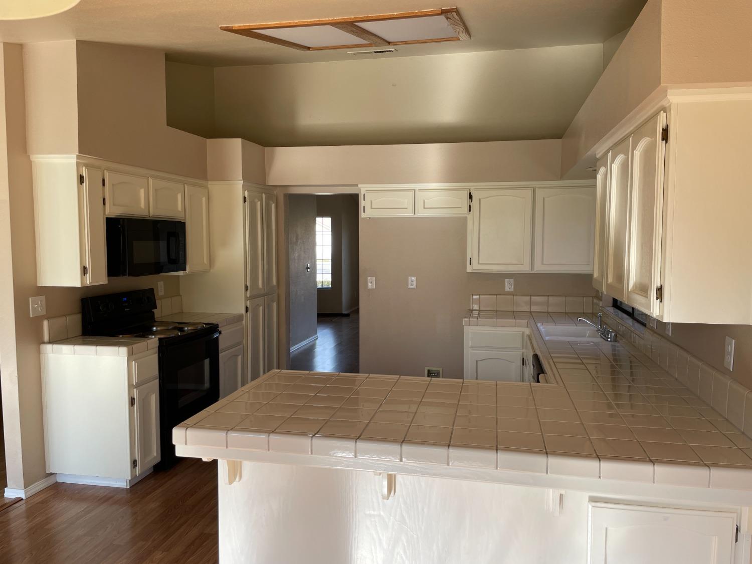 2586 Barstow Avenue Clovis, CA 93611 - Photo 6 of 10 a large kitchen with kitchen island granite countertop a sink and a stove top oven