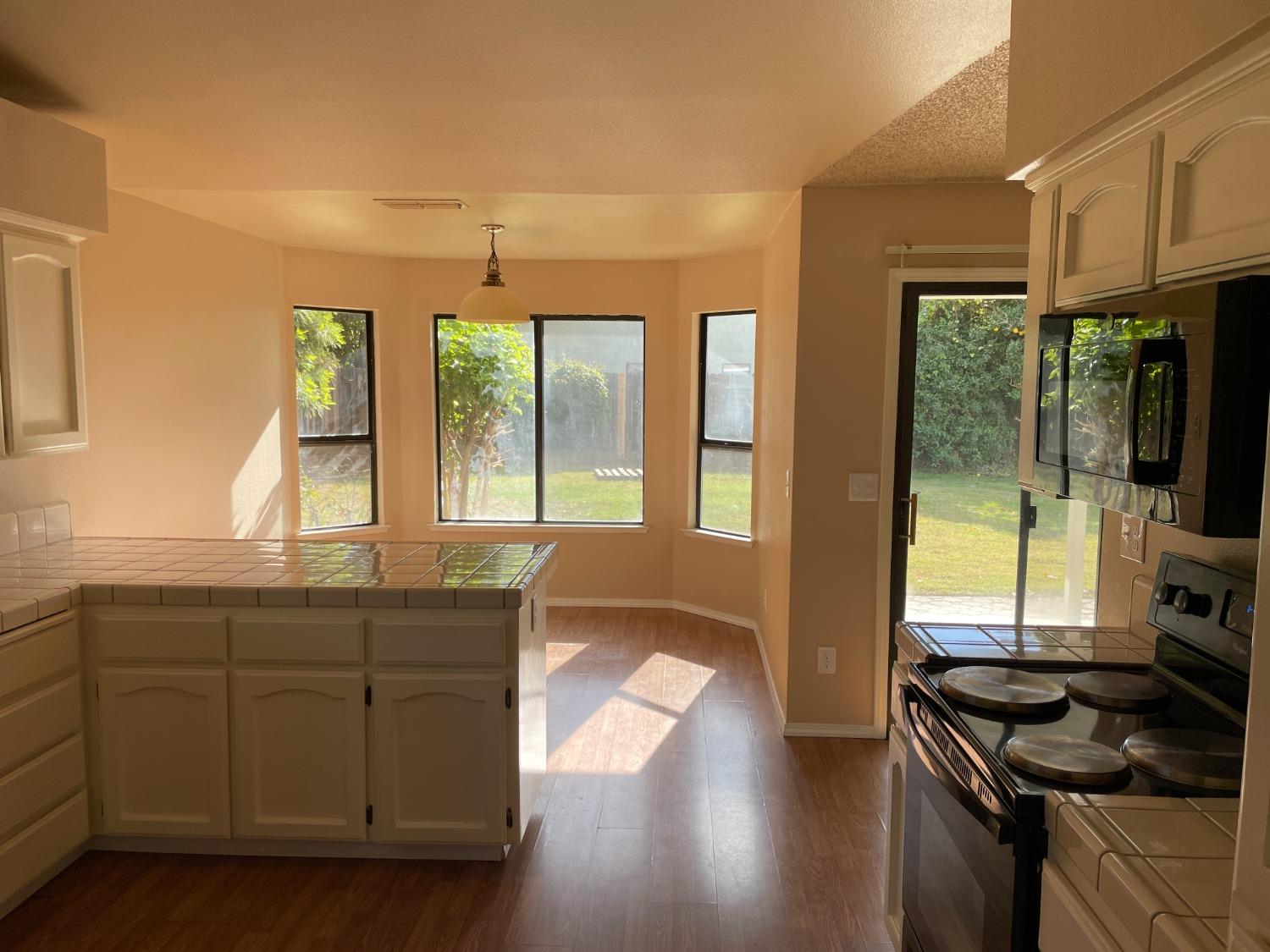 2586 Barstow Avenue Clovis, CA 93611 - Photo 7 of 10 a kitchen with granite countertop a stove a sink and wooden cabinets