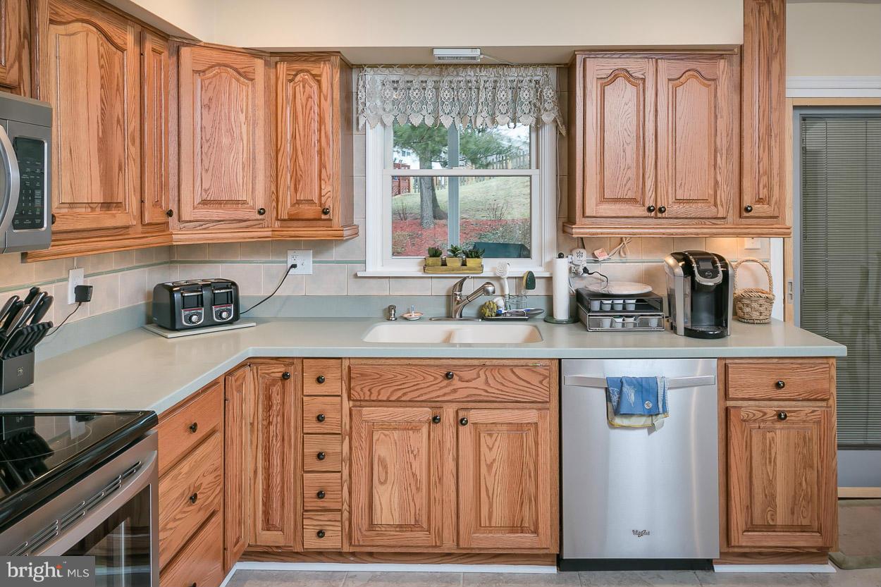 9408 Oak White Road Baltimore, MD 21236 - Photo 12 of 30 a kitchen with stainless steel appliances granite countertop a sink a stove and cabinets