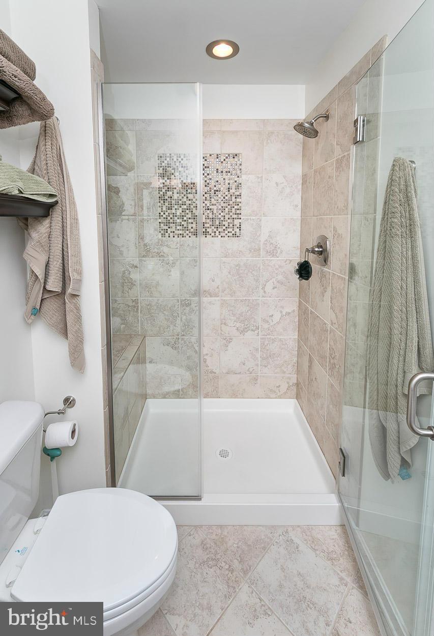 9408 Oak White Road Baltimore, MD 21236 - Photo 20 of 30 a white toilet sitting next to a bath tub and a shower