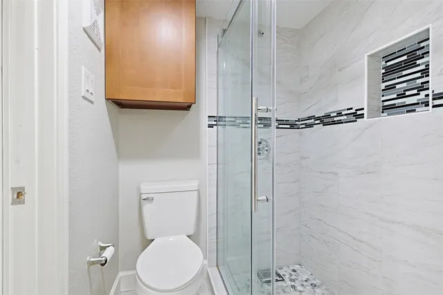 an empty room with wooden floor and ceiling fan