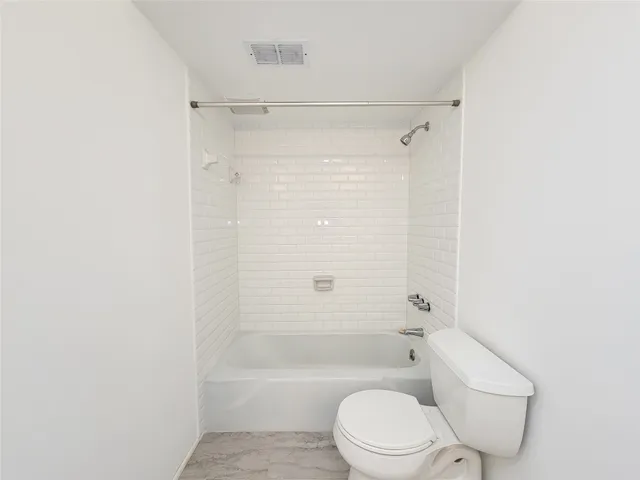 a view of an empty room with a ceiling fan and wooden floor