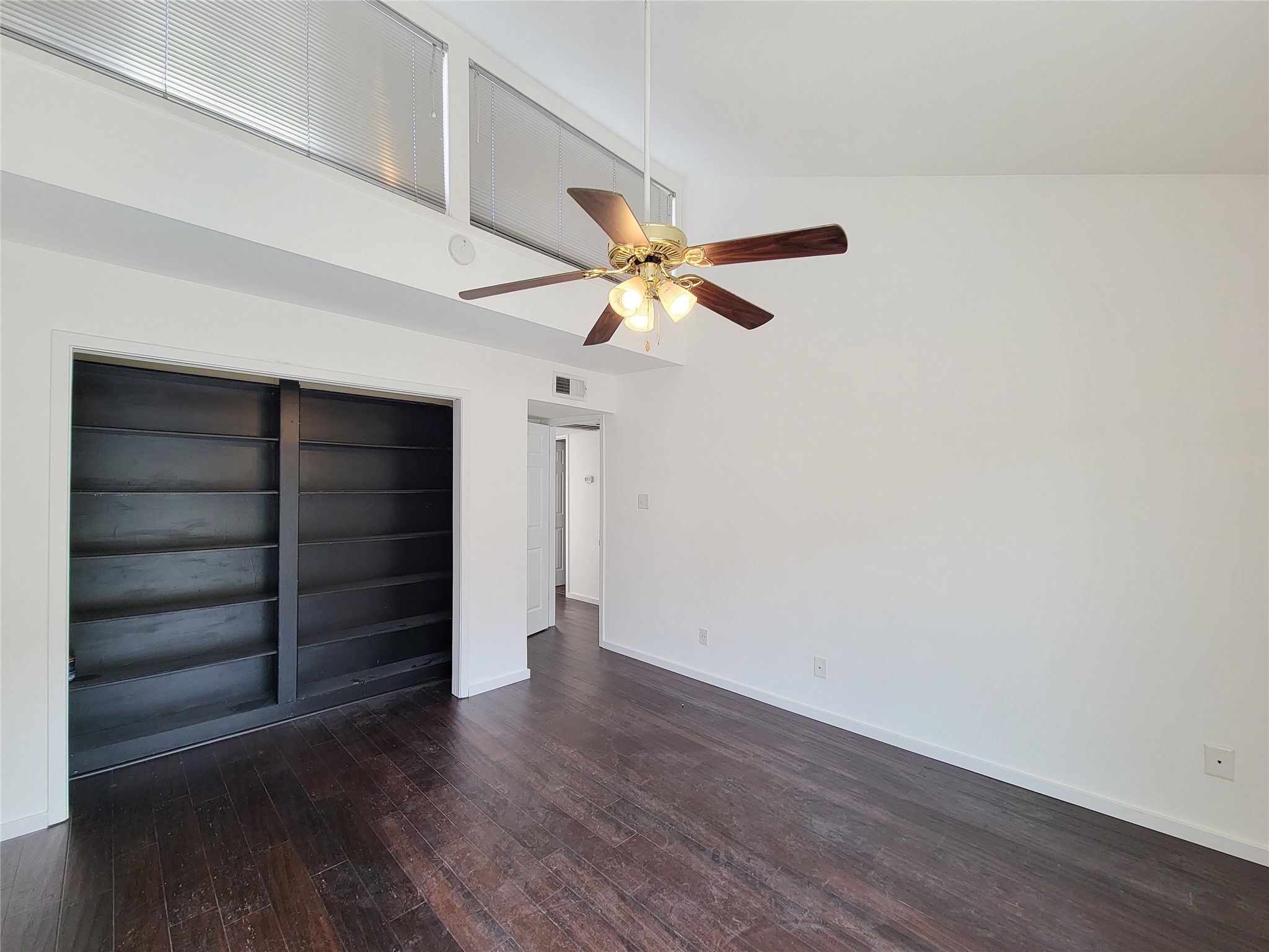 2243 West Alabama Street, Unit B Houston, TX 77098 - Photo 28 of 44 a view of an empty room with a ceiling fan and wooden floor