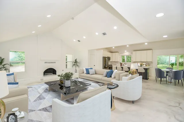 a living room with fireplace furniture and a dining table