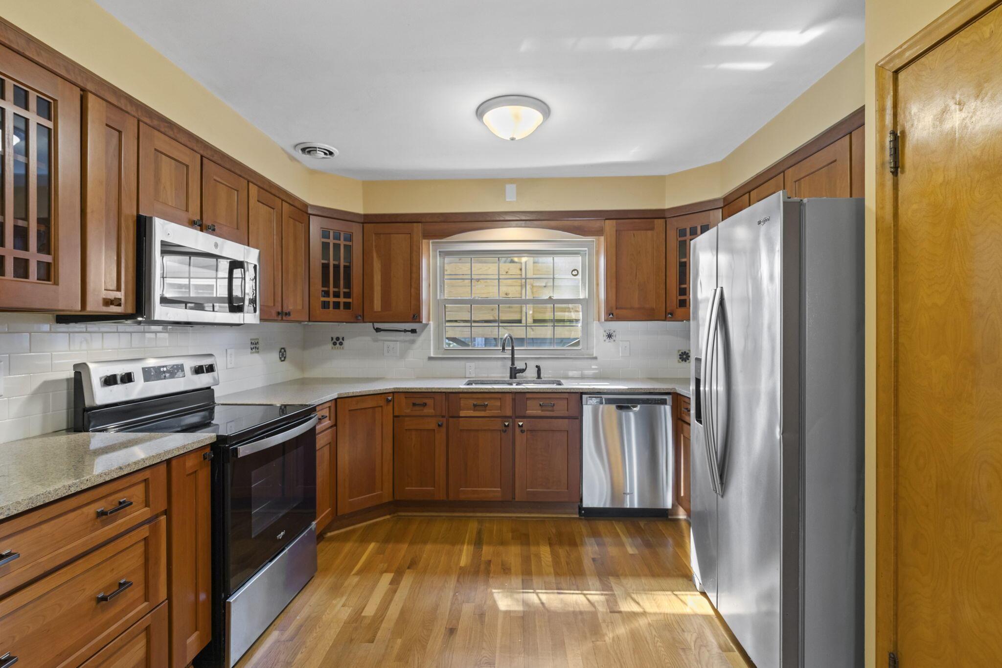 40 South Kellner Road Columbus, OH 43209 - Photo 4 of 57 Kitchen featuring wood-finish cabinetry, stainless steel appliances, light-toned countertops, and wood-finish flooring