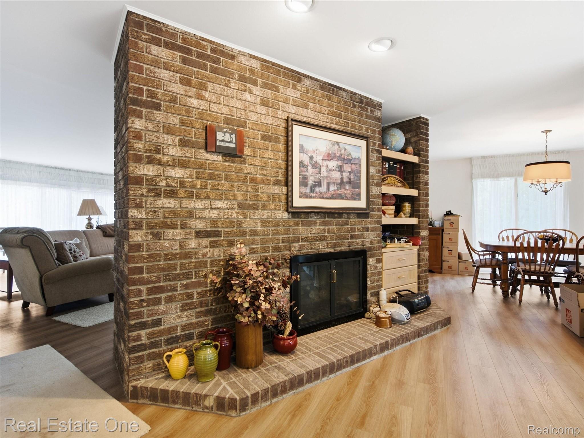 2626 West Wattles Road Troy, MI 48098 - Photo 10 of 65 Brick fireplace with a raised hearth, wood-finish flooring, recessed lighting, and built-in shelving