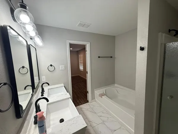 a bathroom with a bathtub sink and mirror