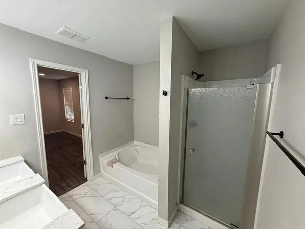 a bathroom with a bathtub and a shower