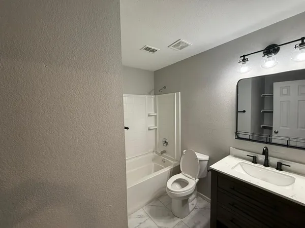 a bathroom with a double vanity sink toilet mirror and shower