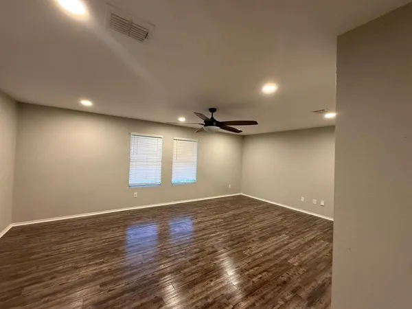 an empty room with wooden floor and windows