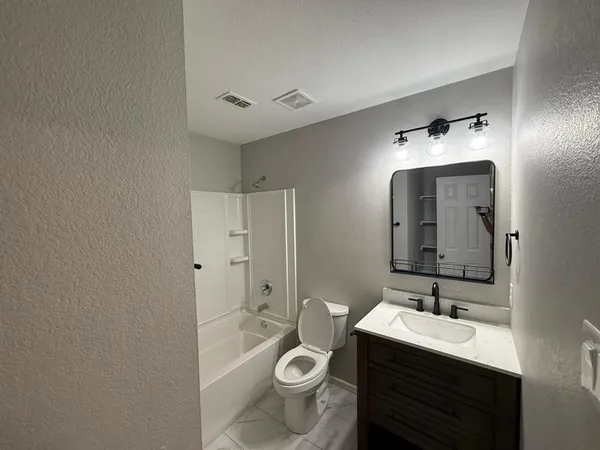 a bathroom with a sink toilet and mirror