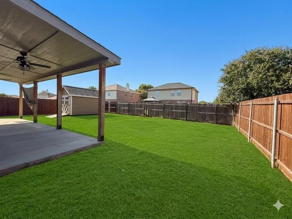 a view of a backyard with a garden and entertaining space