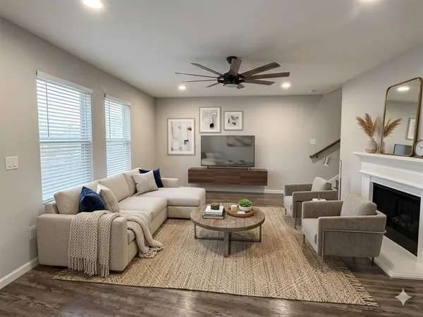 a living room with furniture a fireplace and a large window