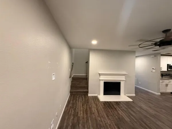 a view of a livingroom with wooden floor and a fireplace