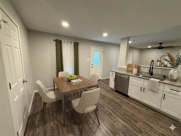 a kitchen with granite countertop white cabinets and stainless steel appliances