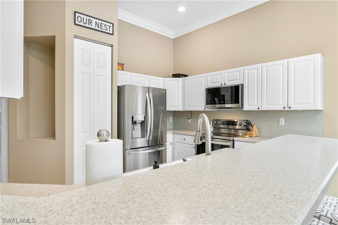 20524 Foxworth Circle Estero, FL 33928 - Photo 15 of 34 a kitchen with stainless steel appliances a refrigerator and a microwave