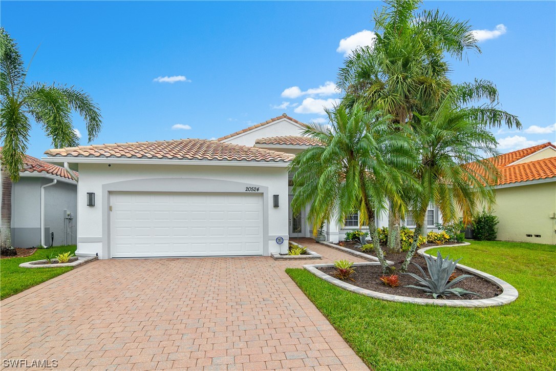 20524 Foxworth Circle Estero, FL 33928 - Photo 2 of 34 a front view of a house with a yard and potted plants