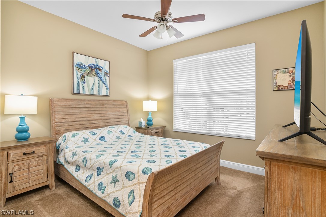 20524 Foxworth Circle Estero, FL 33928 - Photo 24 of 34 a bedroom with a bed dresser and wooden floor
