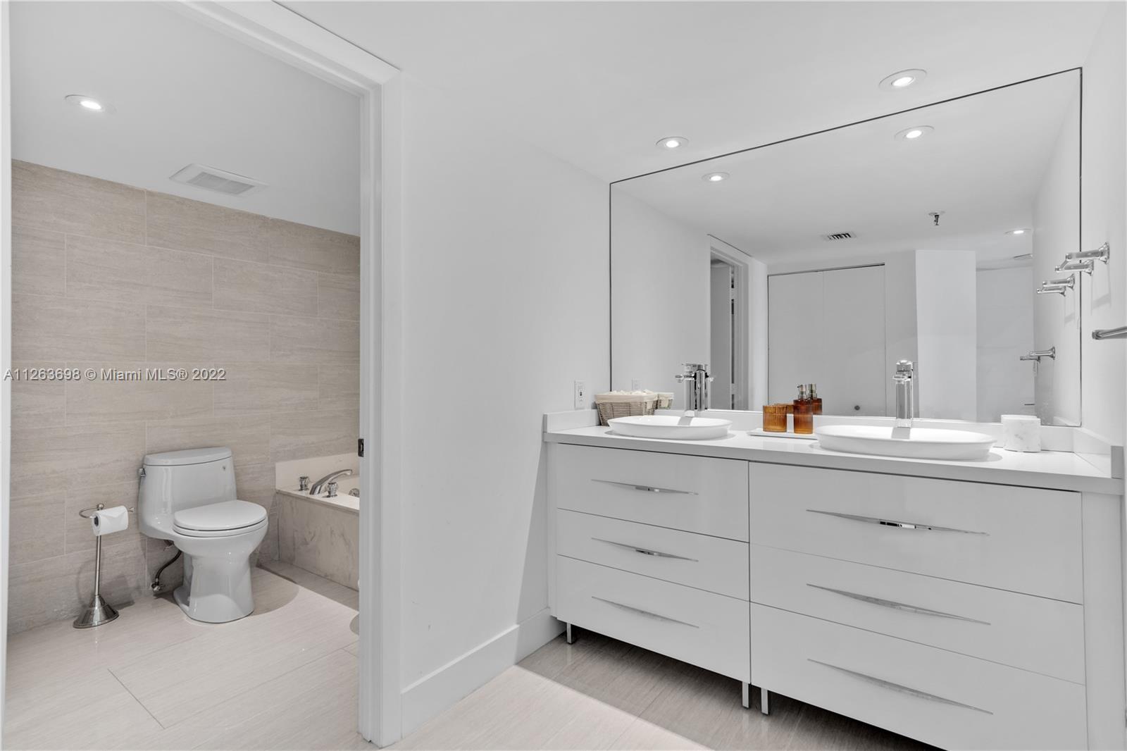 520 Brickell Key Drive, Unit A1819 Miami, FL 33131 - Photo 17 of 35 a bathroom with a toilet sink and mirror