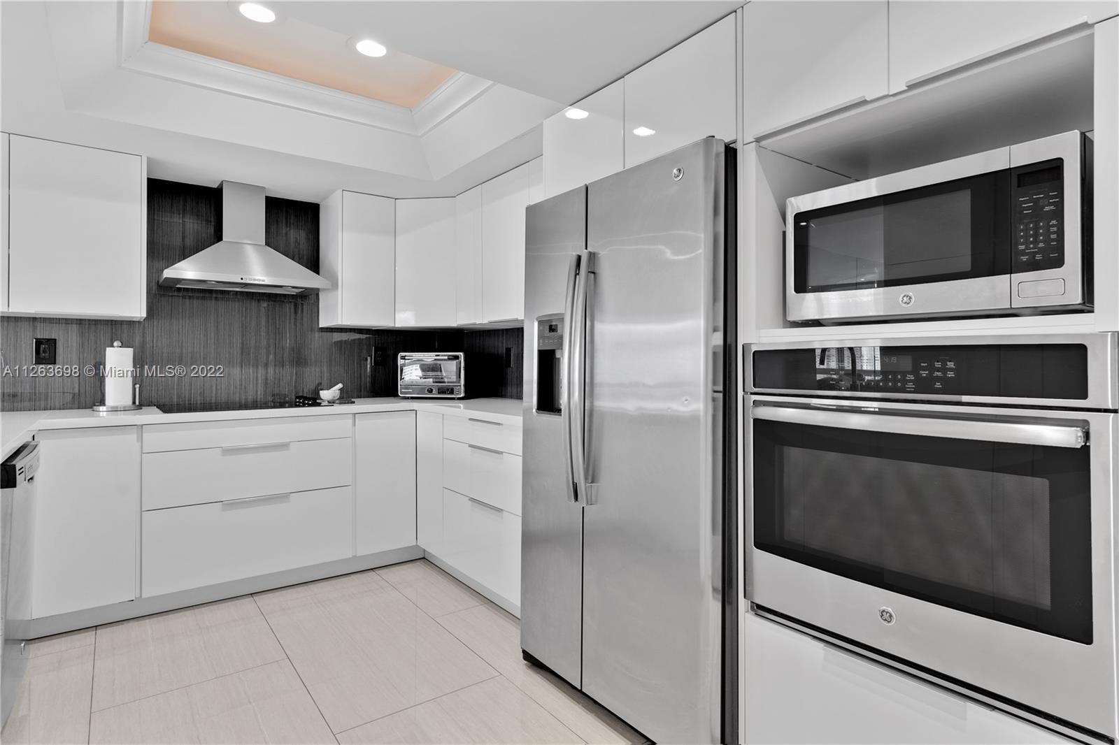 520 Brickell Key Drive, Unit A1819 Miami, FL 33131 - Photo 10 of 35 a kitchen with stainless steel appliances kitchen island granite countertop a stove microwave and refrigerator