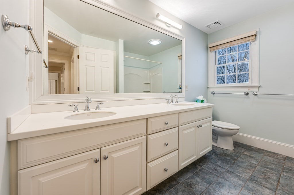 50 Barrett Street Needham, MA 02492 - Photo 24 of 32 a bathroom with a double vanity sink a toilet and a window