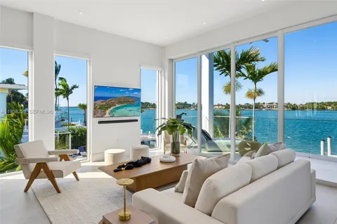 a living room with furniture fireplace and floor to ceiling windows