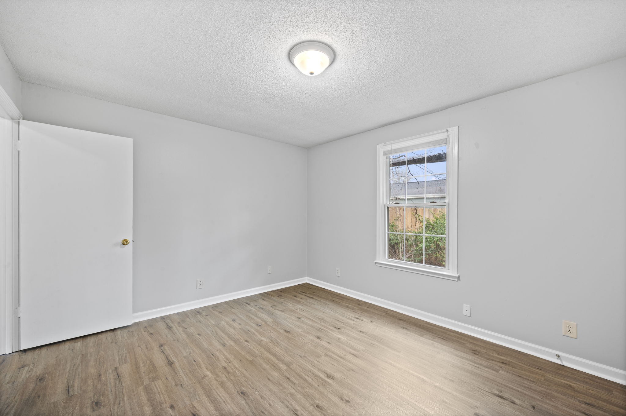 703 Power Street, Unit F Clarksville, TN 37042 - Photo 4 of 13 an empty room with a window and wooden floor