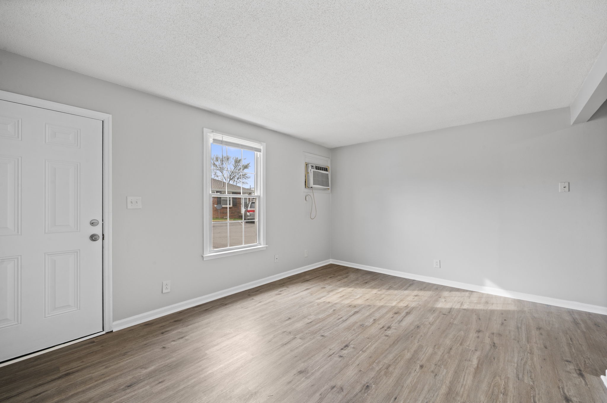 703 Power Street, Unit F Clarksville, TN 37042 - Photo 6 of 13 a view of an empty room with wooden floor and a window