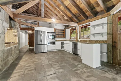a large white kitchen with sink and cabinets