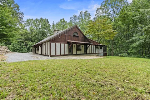 a front view of house with yard and trees around