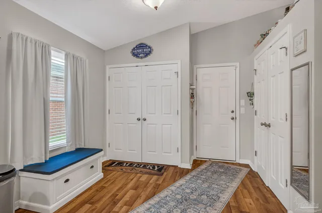 a hallway with front door wooden floor and windows