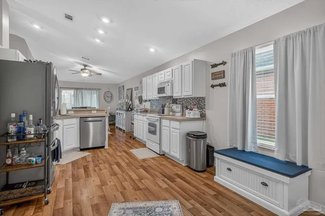a kitchen with stainless steel appliances granite countertop a refrigerator sink and stove