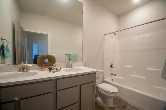 a bathroom with a double vanity sink toilet mirror and shower