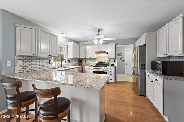 a kitchen with refrigerator and chairs