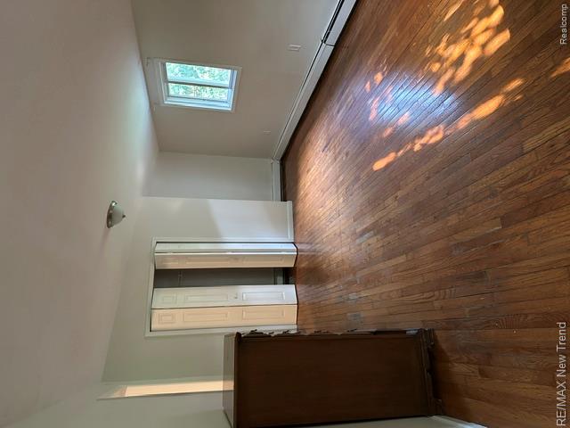 4510 West Maple Road Bloomfield Hills, MI 48301 - Photo 13 of 13 Hardwood flooring, painted walls, white trim, bifold closet doors, and a ceiling-mounted light fixture