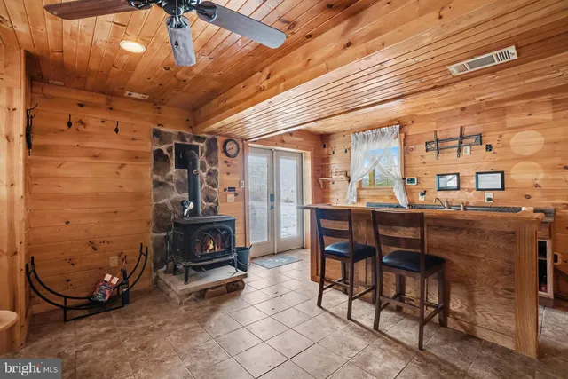 a kitchen with stainless steel appliances kitchen island granite countertop a refrigerator a stove top oven a sink with island and chairs