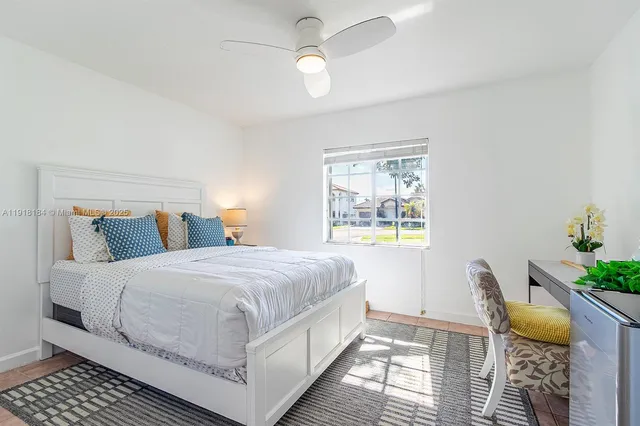 a living room with patio furniture and a potted plant