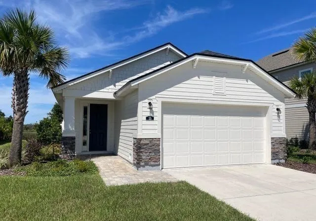 a view of a house with a small yard plants and palm trees