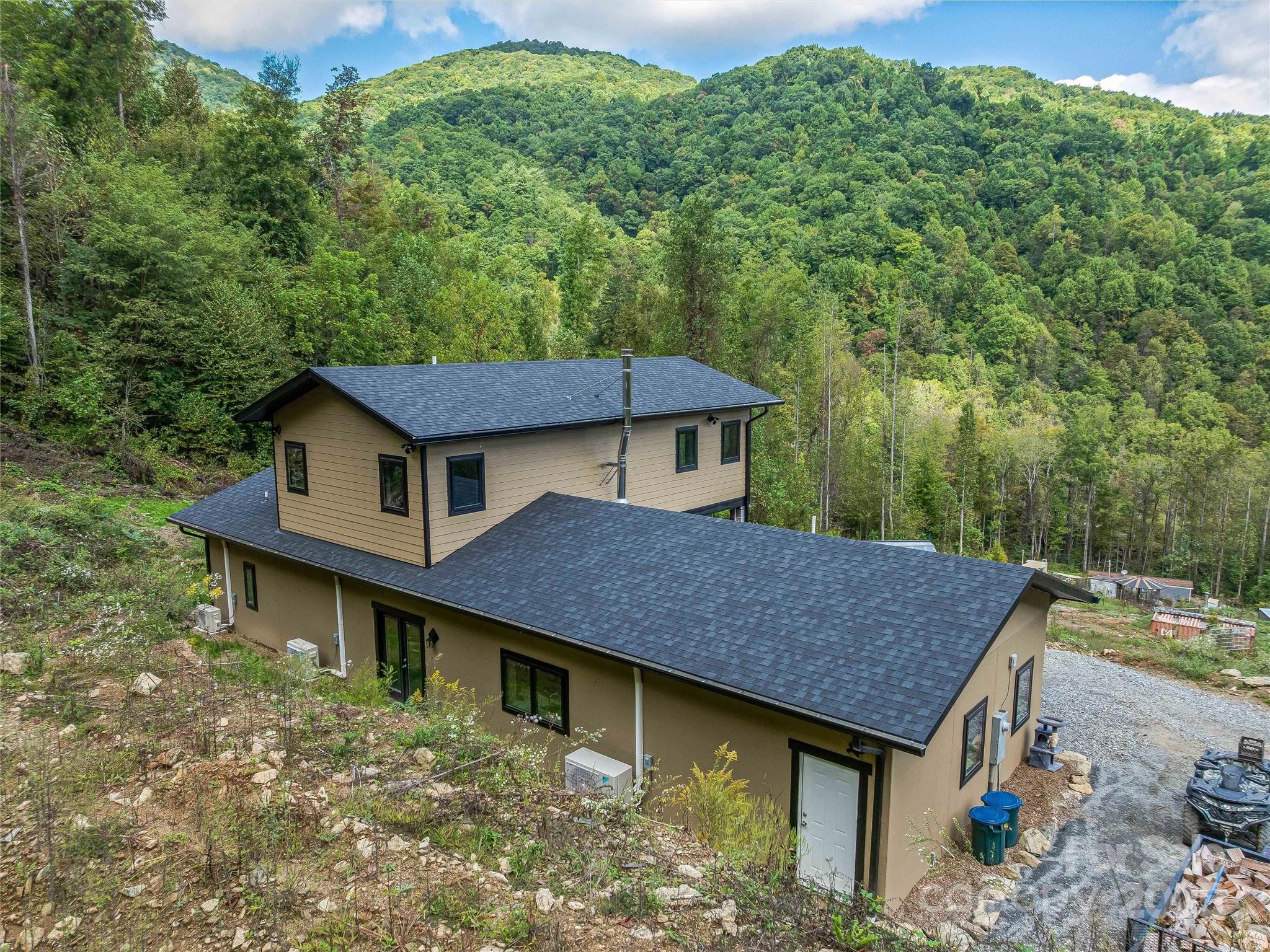 945 Roaring Fork Road Hot Springs, NC 28743 - Photo 24 of 48 an aerial view of a house roof deck with table and chairs under an umbrella