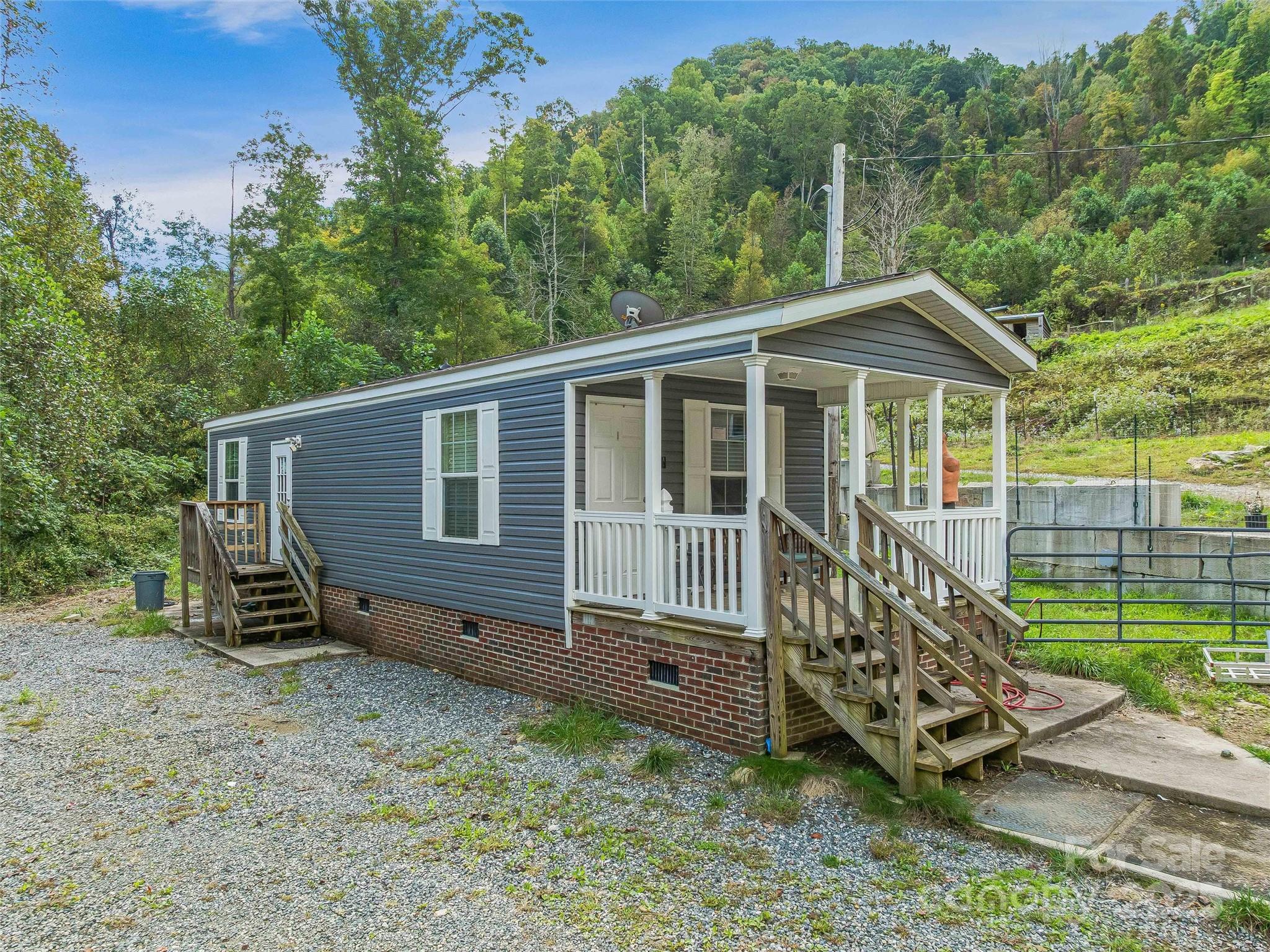 945 Roaring Fork Road Hot Springs, NC 28743 - Photo 26 of 48 a view of a house with a yard and wooden fence