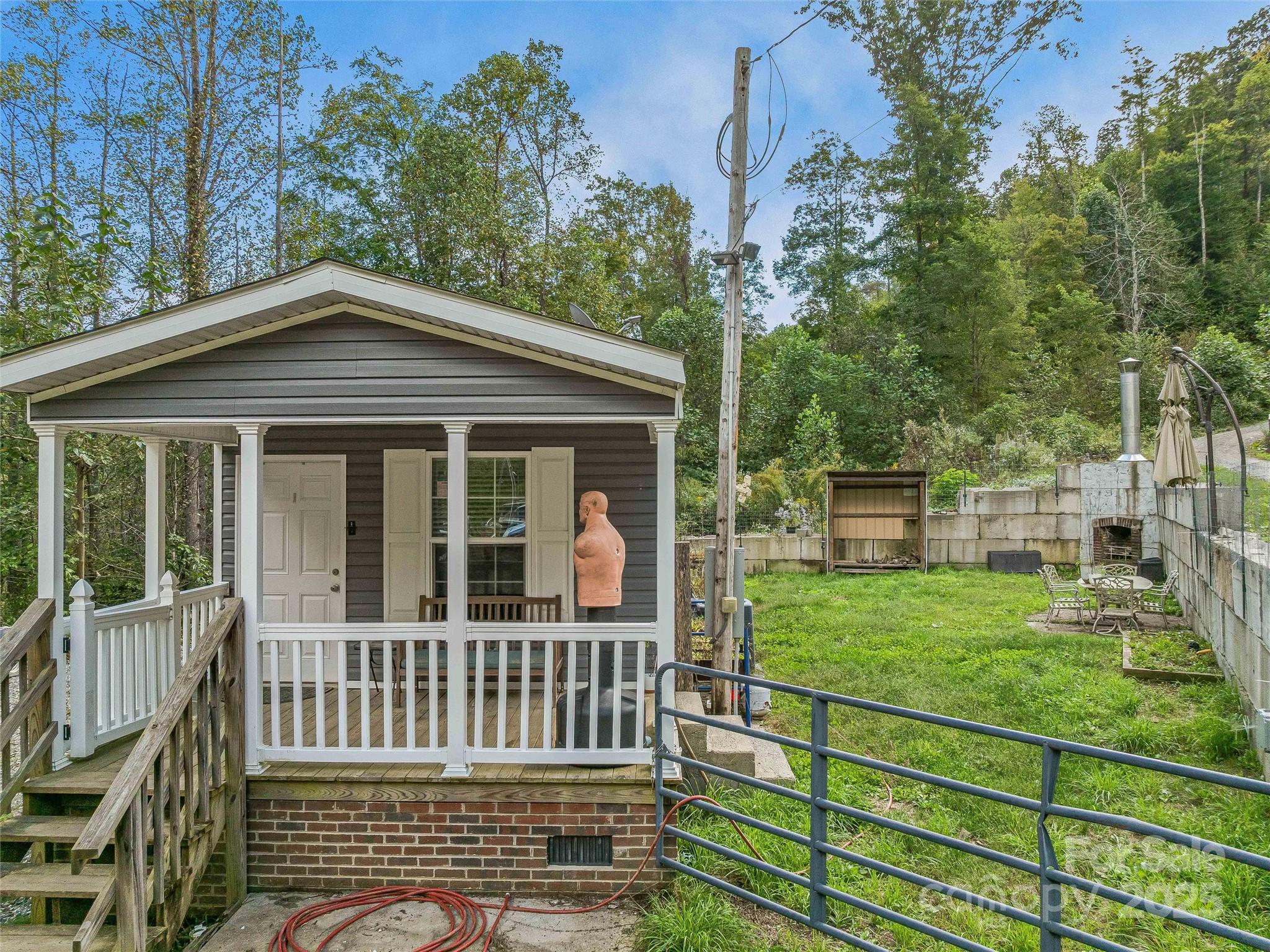 945 Roaring Fork Road Hot Springs, NC 28743 - Photo 27 of 48 a view of a house with a small yard and wooden fence